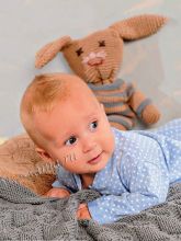 Покрывало, подушка и игрушечный заяц в пуловере, фото