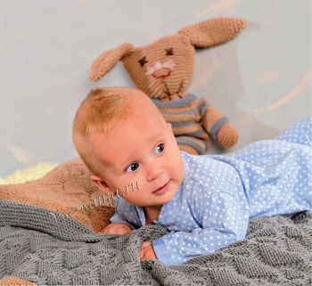 Покрывало, подушка и игрушечный заяц в пуловере, фото